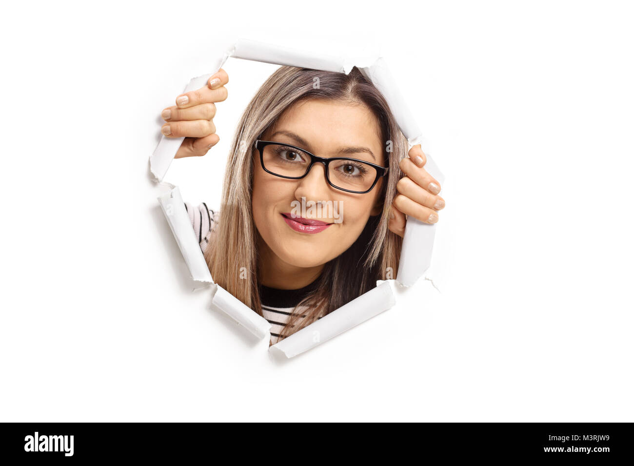 Young woman peeping through a paper hole isolated on white background Stock Photo