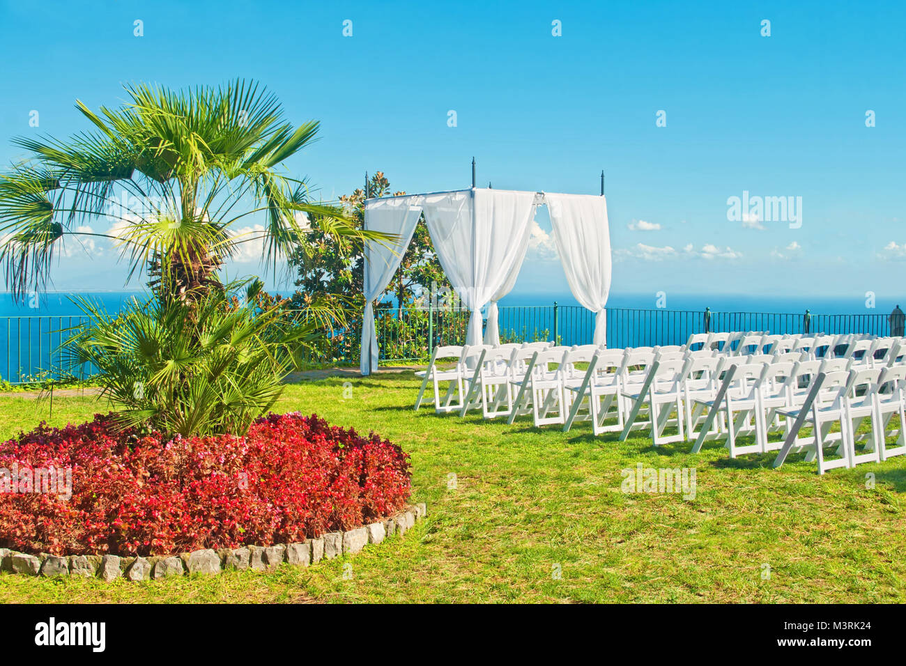 white chairs and arch prepared for wedding ceremony on terrace with sea view on sunny summer day in Ravello, Amalfi, Italy Stock Photo