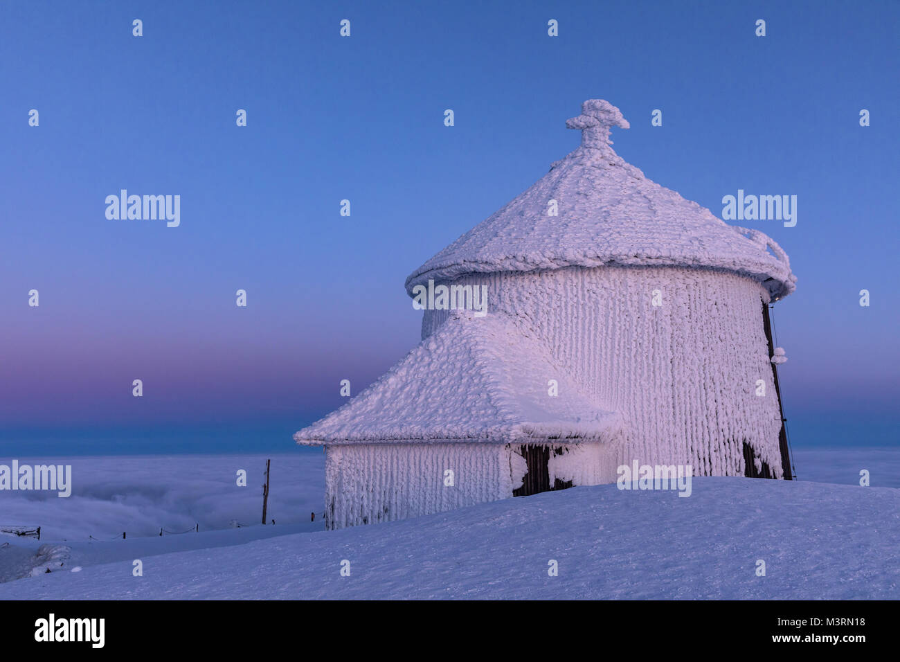 The peak of the Snezka Mountain in winter in the Krkonose Mountains. Snezka, Krkonose mouintain, Czech Republic, Europe. Snezka after a sunset tinged  Stock Photo