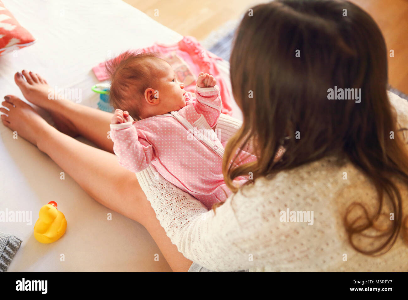 Young mother holding her newborn child. Mom nursing baby. Family at home Close up Stock Photo