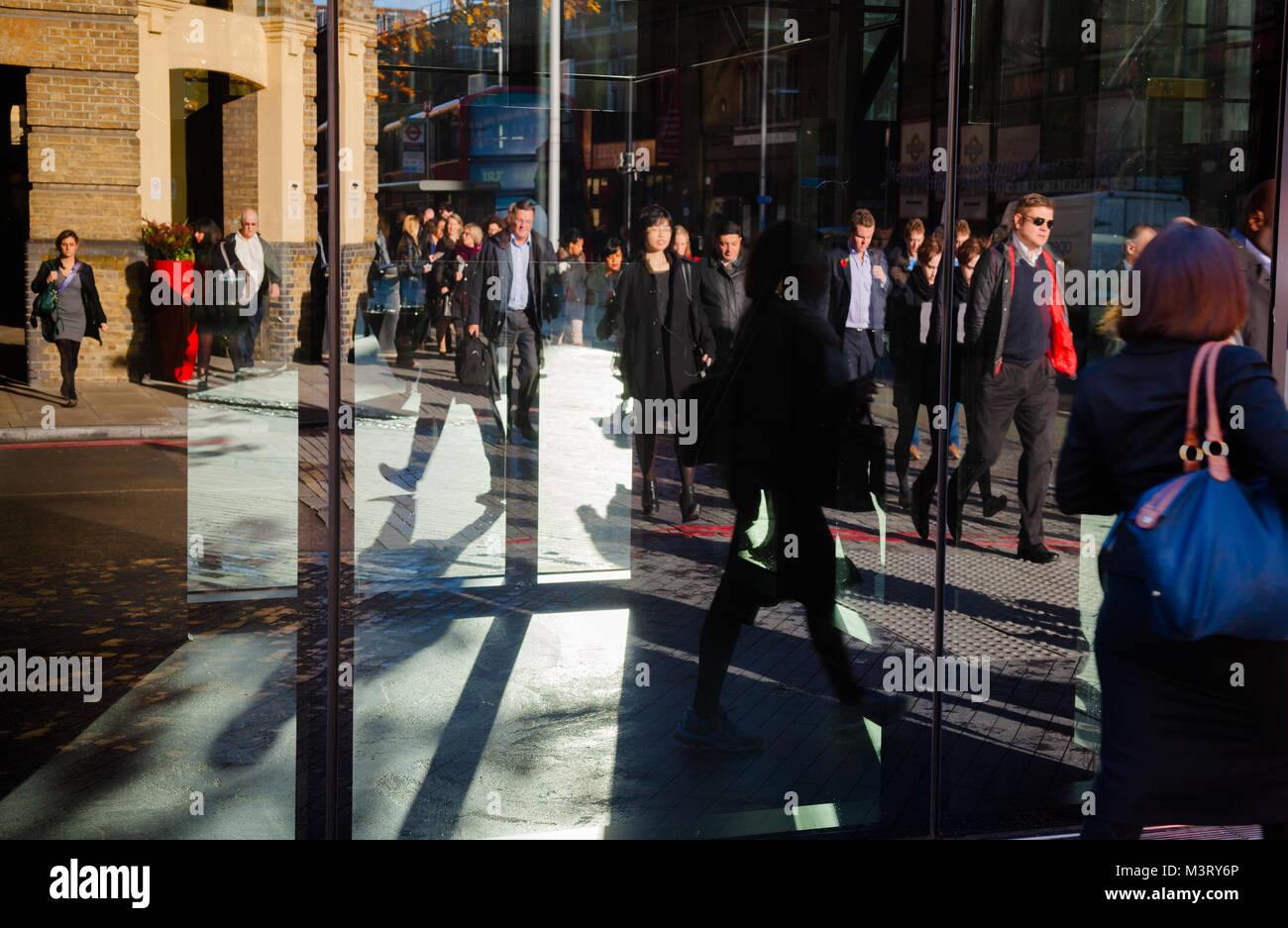 LONDON, UK - NOV 1, 2012: Pedestrians reflecting in an office building window — busy city life concept Stock Photo