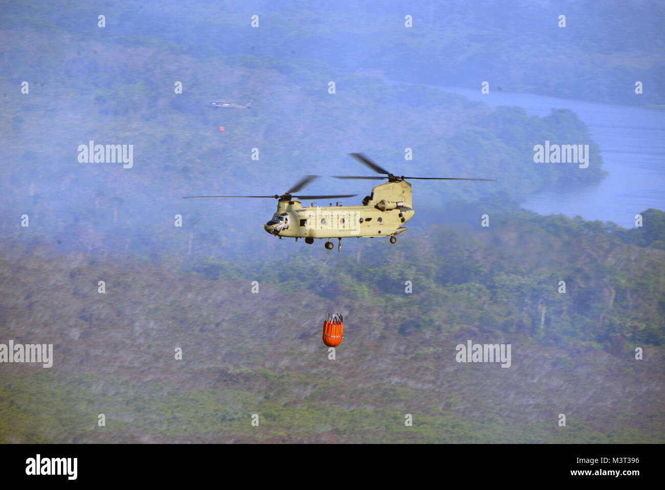 A U.S. Army CH-47 Chinook and UH-60 Black Hawk provide Bambi Bucket firefighting capabilities in support of a Honduran effort to extinguish a forest fire, March 31, 2016, near Tela Honduras, at the request of Honduran President Juan Orlando Hernandez. The two aircraft were a part of a package of helicopters that Joint Task Force-Bravo, located at Soto Cano Air Base, Honduras, sent to help the Hondurans respond to the fire. (U.S. Air Force photo by Staff Sgt. Westin Warburton/ Released) 160331-F-WT432-012 by ussouthcom Stock Photo