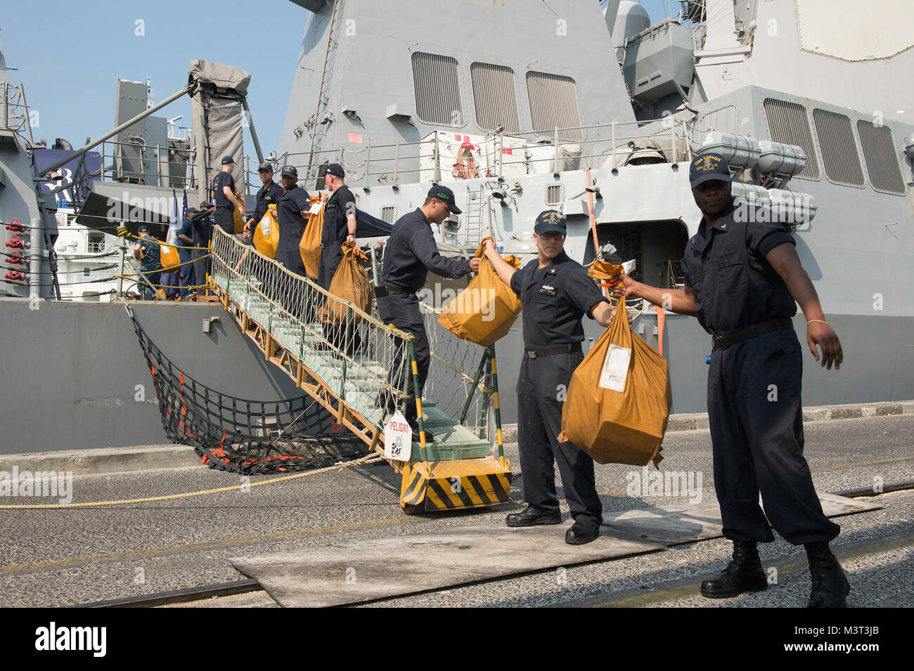 160413-N-MD297-040 ACAJUTLA, El Salvador (April 13, 2016) Sailors assigned to the Arleigh Burke-class guided-missile destroyer USS Lassen (DDG 82) form a line to bring more than 3,000 lbs. of mail onto the ship during a brief stop for fuel (BSF) in Acajutla, El Salvador. Lassen is currently underway in support of Operation Martillo, a joint operation with the U.S. Coast Guard and partner nations within the 4th Fleet area of responsibility. Operation Martillo is being led by Joint Interagency Task Force South, in support of U.S. Southern Command. (U.S. Navy photo by Mass Communication Specialis Stock Photo
