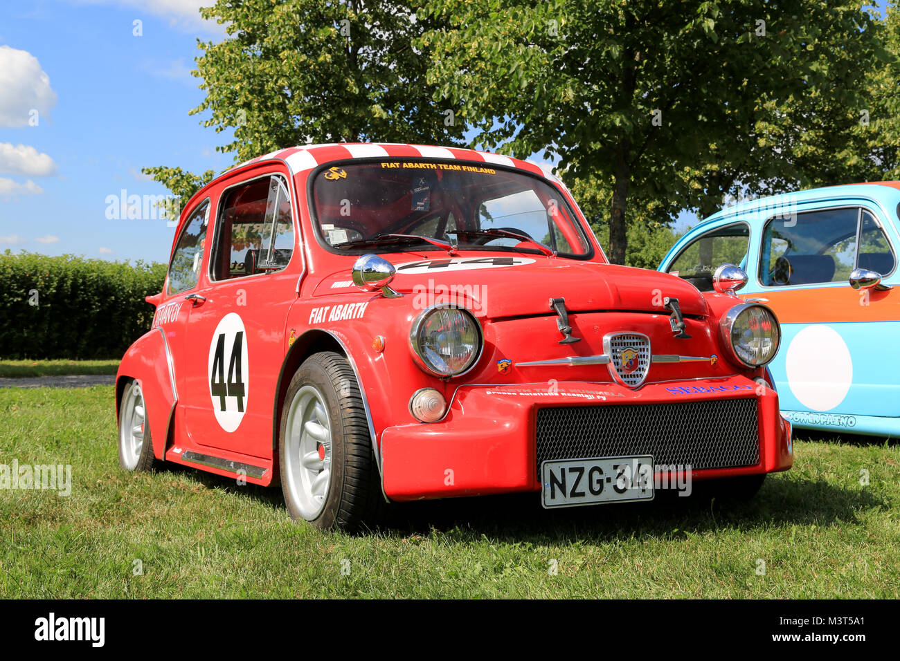 PIIKKIO, FINLAND - JULY 19, 2014: Red Fiat Abarth racing car parked on grass. Abarth began his well-known association with Fiat in 1952. Stock Photo