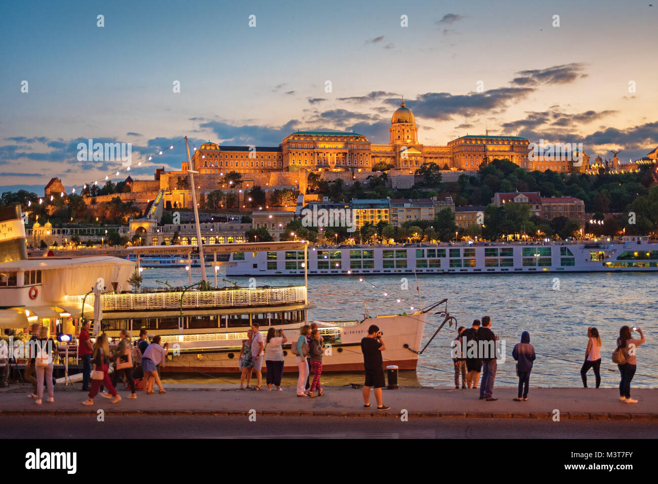 People enjoying Royal Palace view across Danube river at night ...