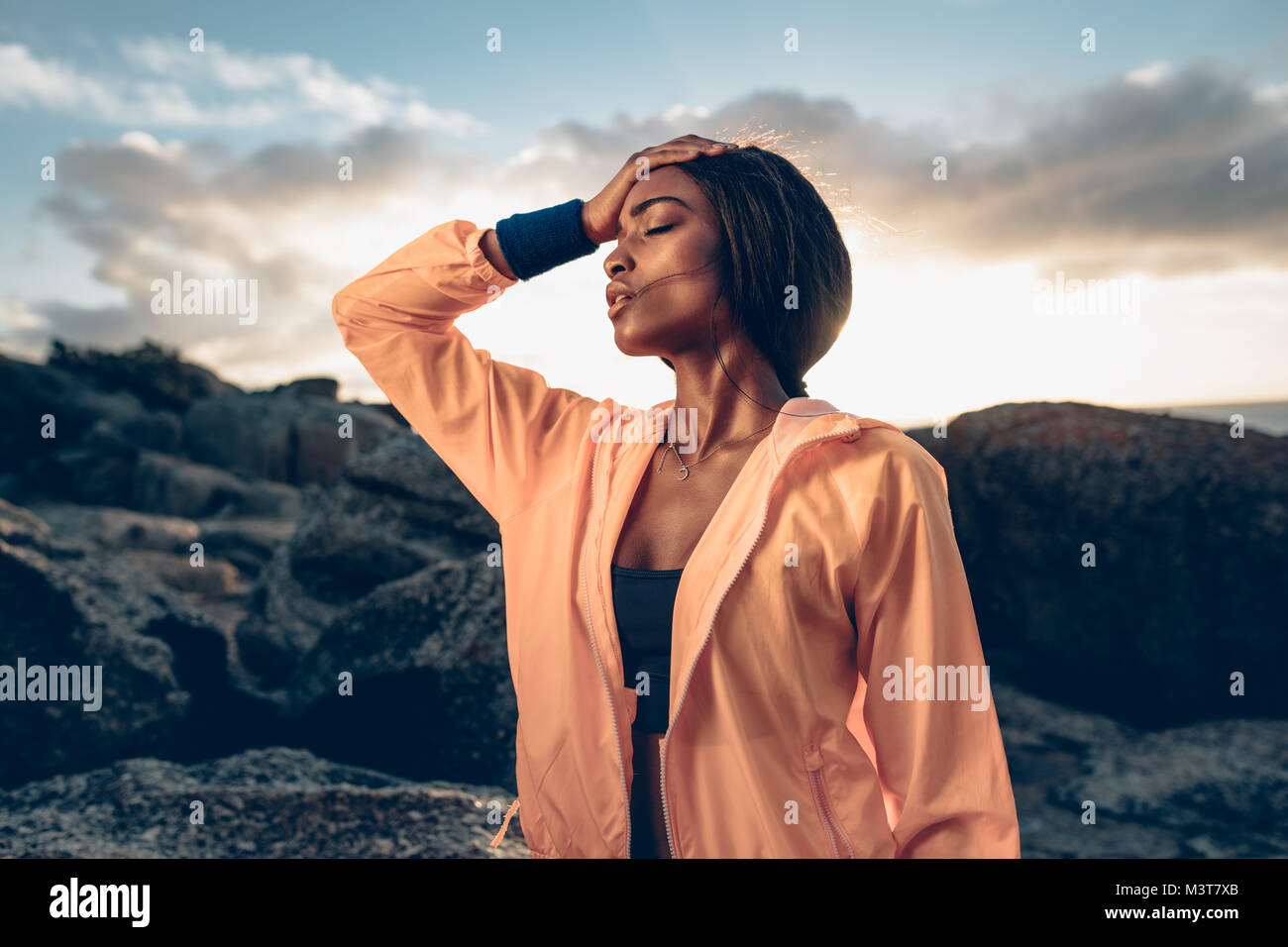 African woman standing with her hand on head after exhaustive workout