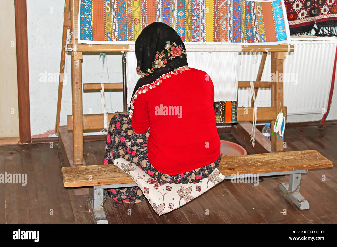 Turkish Woman Making Rug ANTALYA, TURKEY - MAY 02, 2012: Local woman weaves a carpet by hand in ...