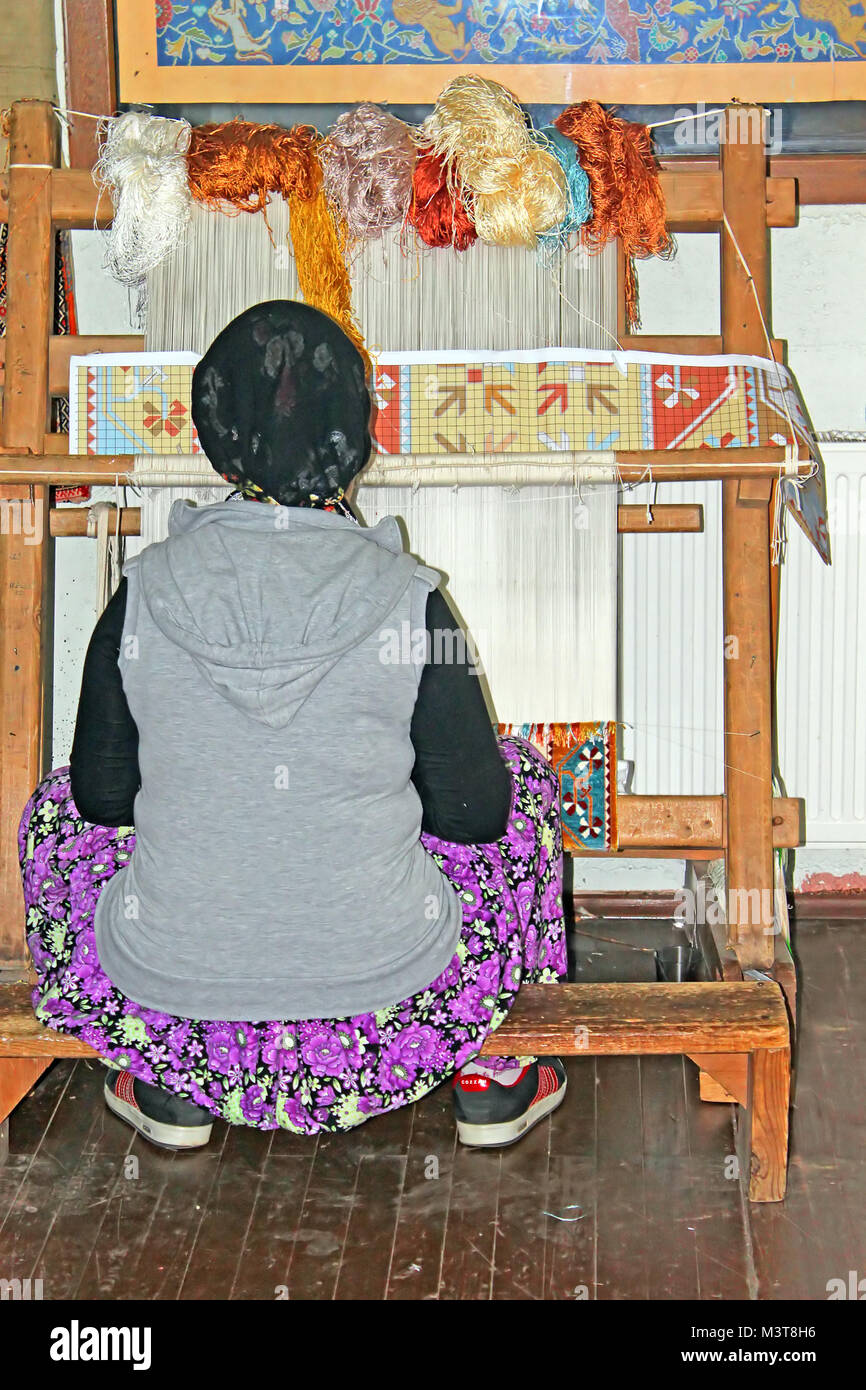Turkish Woman Making Rug ANTALYA, TURKEY - MAY 02, 2012: Local woman weaves a carpet by hand in ...
