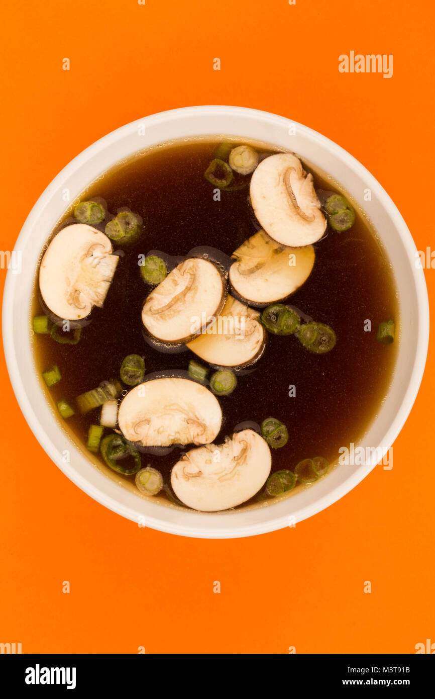 Bowl Of Japanese Style Clear Onion Soup With Mushrooms and Spring