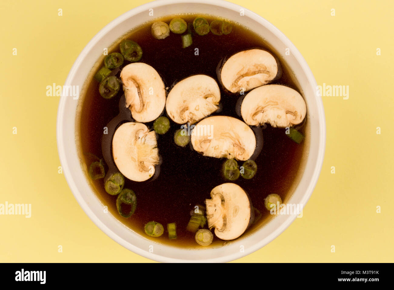 Bowl Of Japanese Style Clear Onion Soup With Mushrooms and Spring