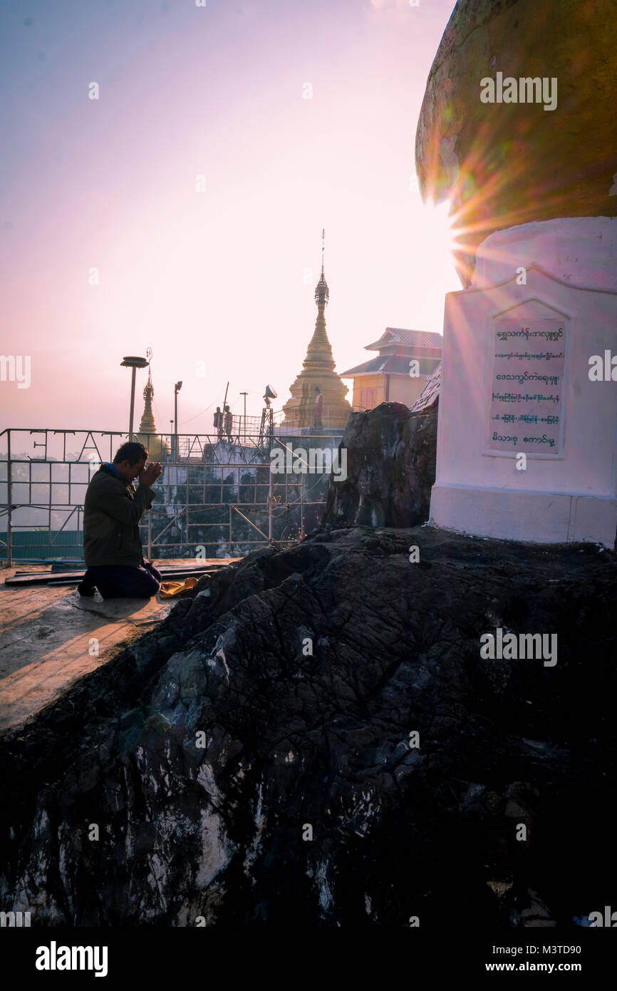Man praying at Taung Kwe Zedi pagoda at sunrise in Loikaw Myanmar Stock Photo