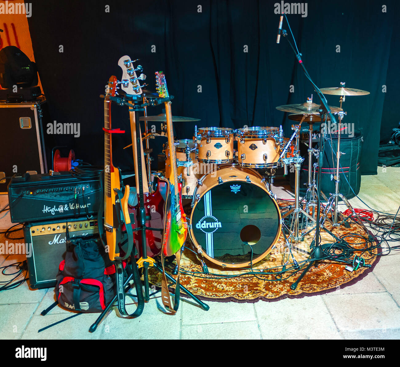 Musical instruments with bass guitar and drums on stage, background of