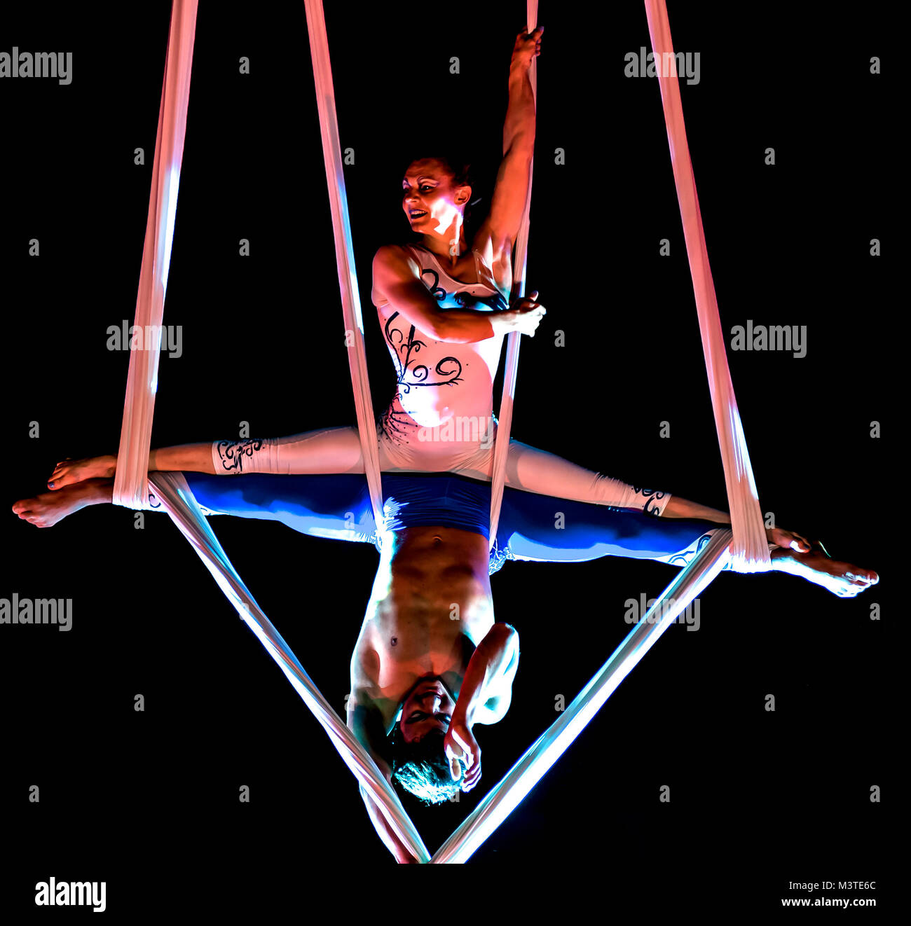 Bitonto, Italy - May 28, 2017: Acrobats perform a trick on slings suspended in the void and secured with harnesses on a festive evening in the main sq Stock Photo