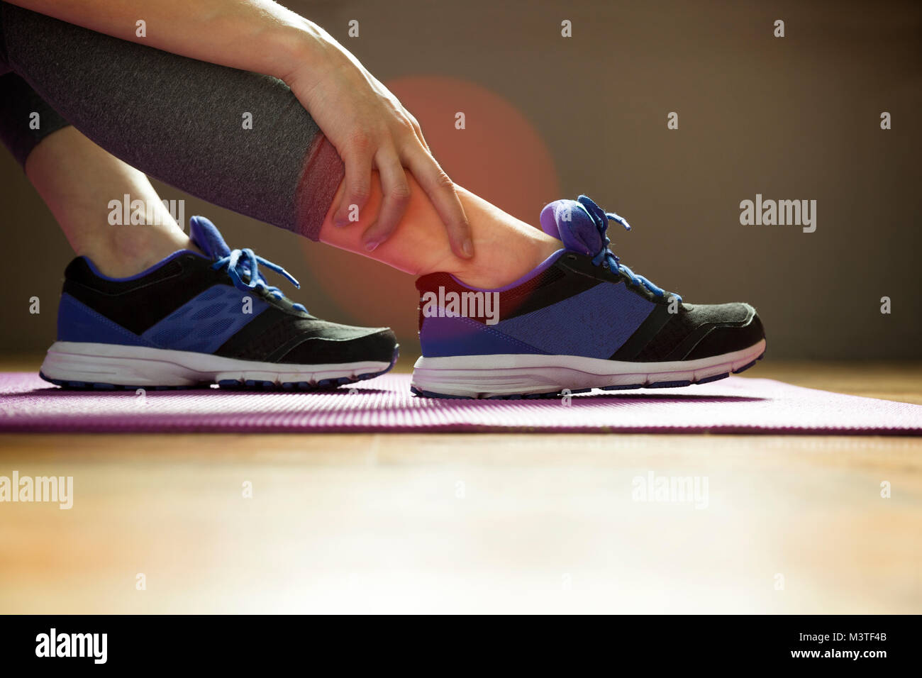 Young woman suffering from an ankle injury while exercising. Sport