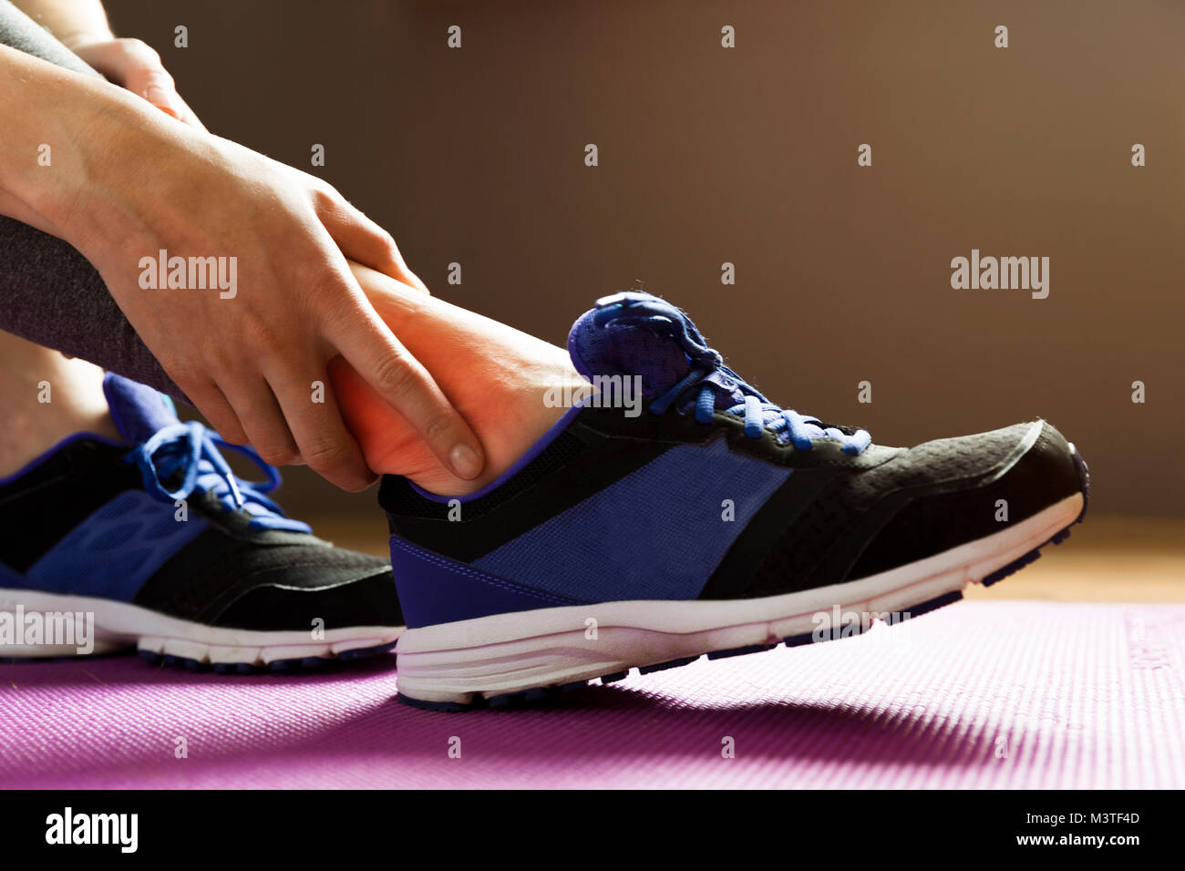 Young woman suffering from an ankle injury while exercising. Sport