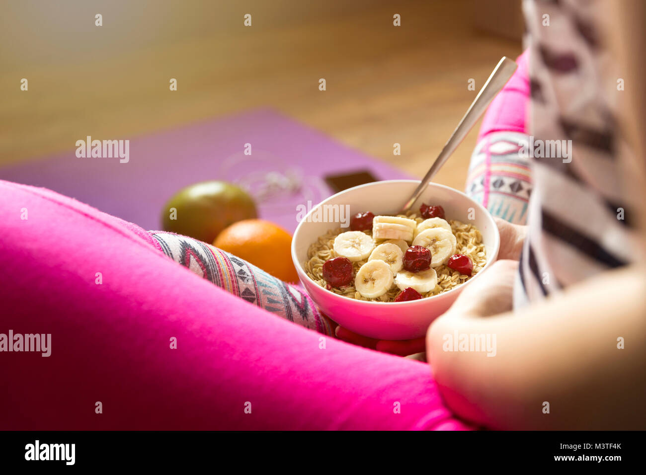 Young girl eating a oatmeal with berries after a workout . Fitness and healthy lifestyle concept. Stock Photo