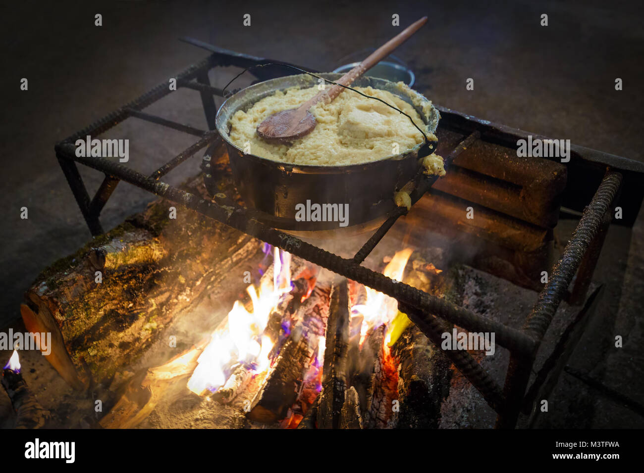 Traditional georgian food, hominy (mamaliga) is cooked in the large cooking pot on fire Stock Photo