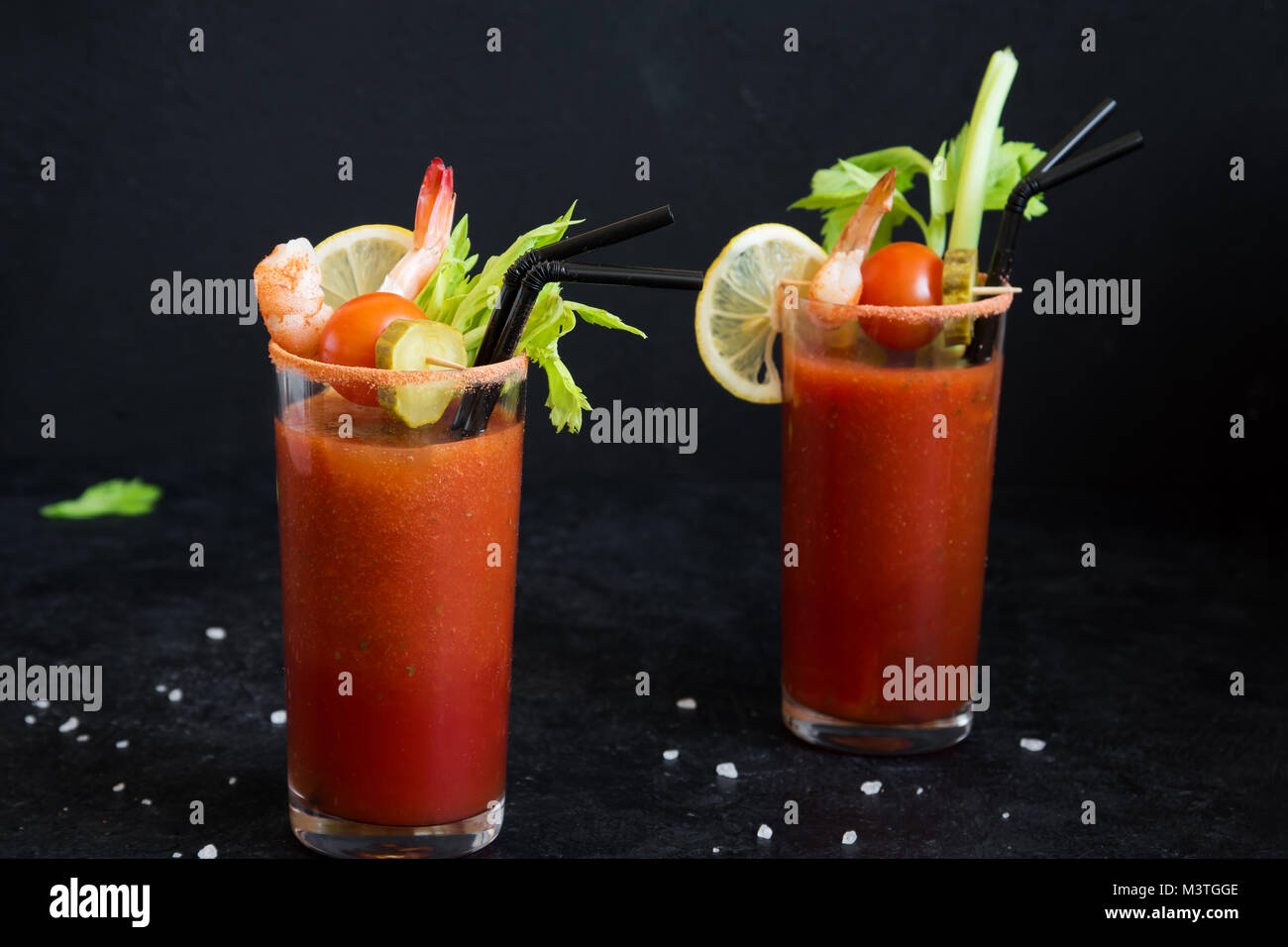 Bloody Mary Cocktail in glasses with garnishes. Tomato Bloody Mary spicy  drink on black stone background with copy space Stock Photo - Alamy