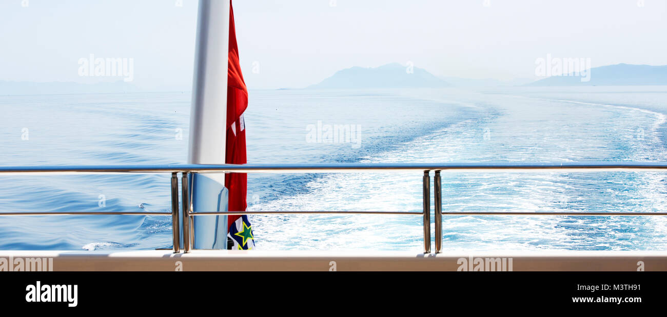 A view from the back of a super yacht cruising the mediterranean. Stock Photo