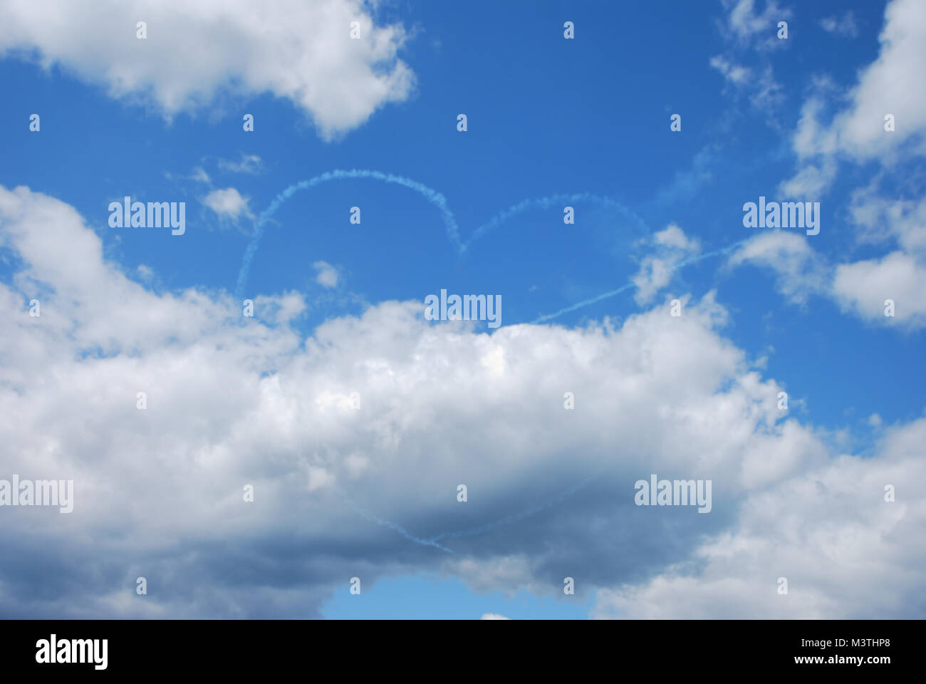 two planes make with fog effect on the heart with blue sky flugshow Stock Photo