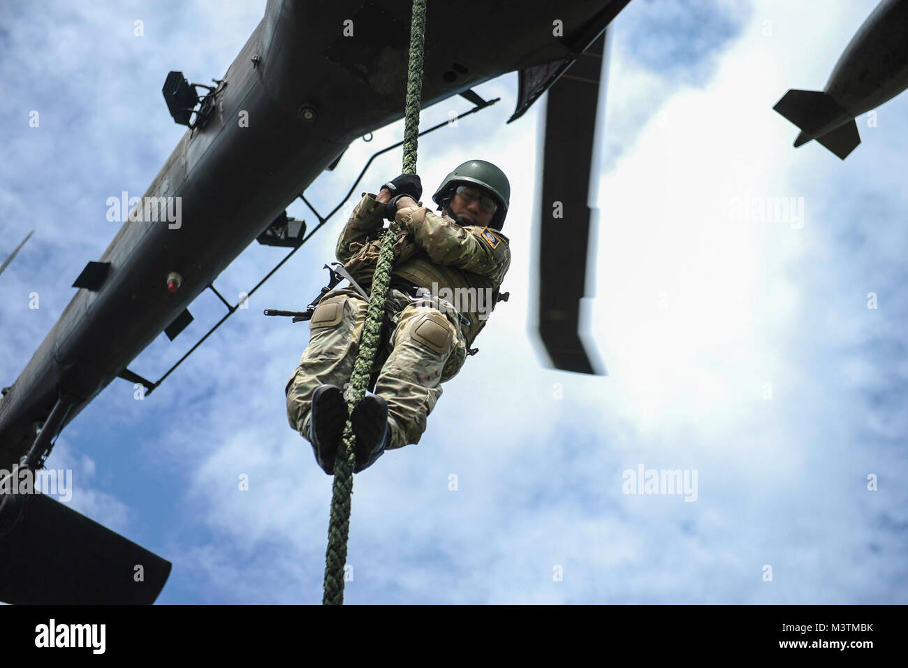 A member of the Belize Special Assignment Group fast ropes out of a UH-60 Black Hawk assigned to Joint Task Force-Bravo’s 1st Battalion, 228th Aviation Regiment during training at Price Barracks, Belize, July 19, 2016. For many of the BSAG participants, this was their first time they were part of Fast Rope Insertion and Extraction System (FRIES) training. (U.S. Air Force photo illustration by Staff Sgt. Siuta B. Ika) 160719-F-JB386-384 by ussouthcom Stock Photo