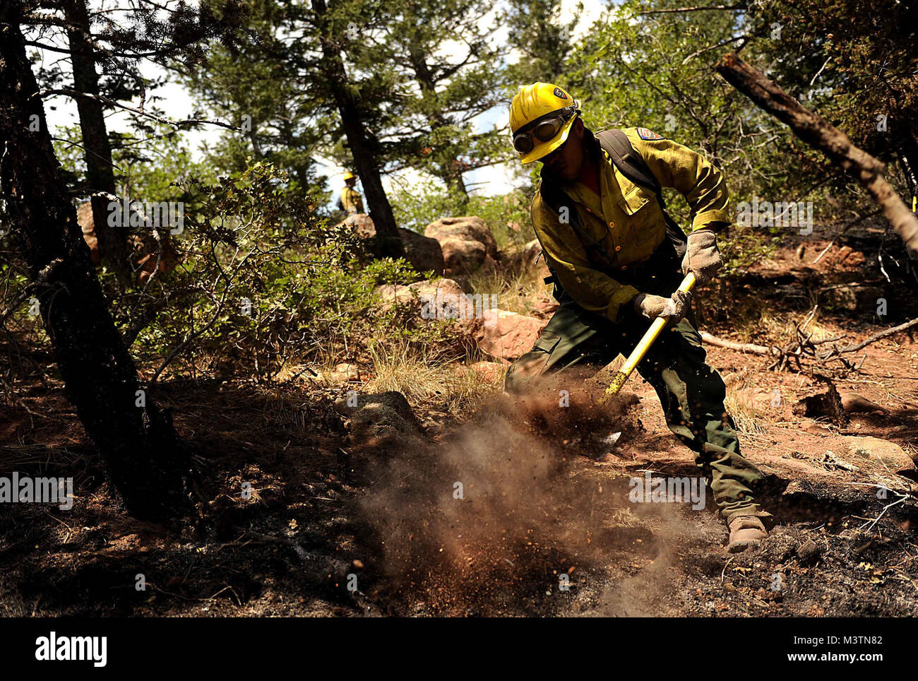 Vandenberg Air Force Base Hot Shot fire fighter Lupe Covarrubias cuts a fire line on June 28, 2012 in the Mount Saint Francois area of Colorado Springs, Co. while helping to battle several fires in Waldo Canyon.  The Waldo Canyon fire has grown to 18,500 acres and burned over 300 homes. Currently, more than 90 firefighters from the Academy, along with assets from Air Force Space Command; F.E. Warren Air Force Base, Wyo.; Fort Carson, Colo.; and the local community continue to fight the Waldo Canyon fire.(U.S. Air Force Photo by: Master Sgt. Jeremy Lock) (Released) 120628-F-JQ435-033 by AirmanM Stock Photo