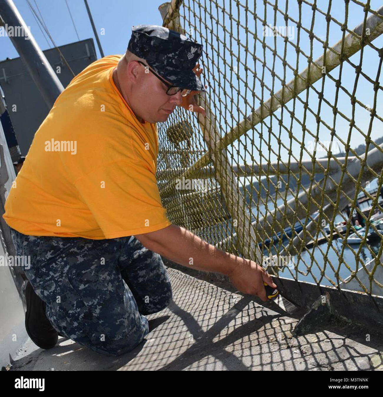 160817-N-SP496-045 BREMERTON, Wash. (Aug. 17, 2016) - Yeomen Chief select Bradley Daly of the USS Alabama Blue crew is chipping old paint for the USS Turner Joy repainting. USS Turner Joy Chief Petty Officer Legacy Academy gives recent chief selectees the privilege of attending as Class 008. Through the week they will reside aboard the vessel and participate in a variety of activities, providing a continuous lesson in heritage and teamwork. (U.S. Navy photo by Airman Jane Wood) 160817-N-SP496-045 by Naval Base Kitsap (NBK) Stock Photo