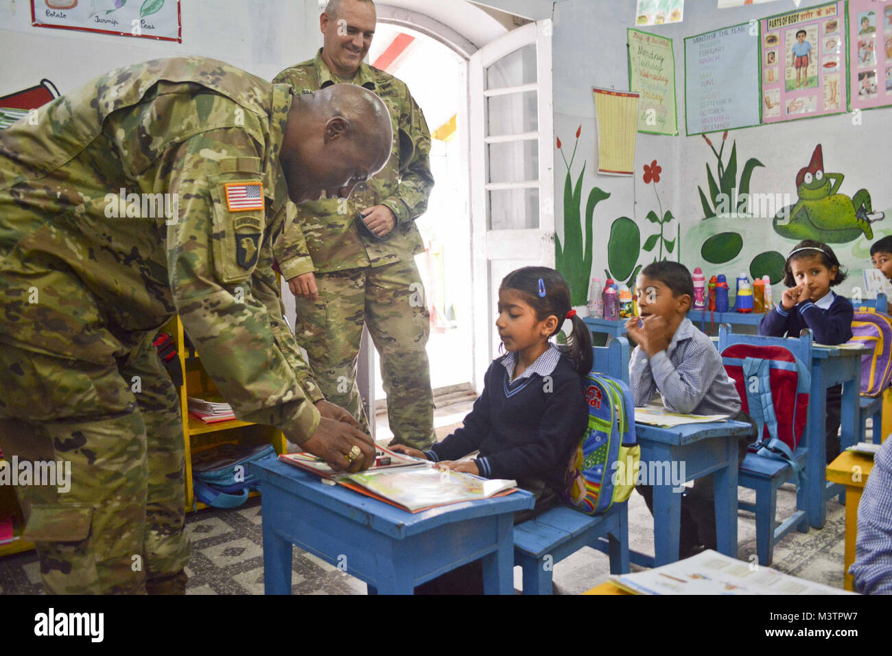 Command Sgt. Maj. Wilson, the senior enlisted advisor for 1-2 Stryker Brigade Combat Team, gives a student school supplies Sept. 19, 2016, at Chaubattia Military Station, India. The 1-2 SBCT command team was in India for Yudh Abhyas 2016, a bilateral training exercise geared toward enhancing cooperation and coordination between the U.S. and Indian armies through training and cultural exchanges. (U.S. Army photo by Spc. Gurpreet Gill)  u2018Ghost Brigade u2019 command team visits Indian school children by 1-2 Stryker Brigade Combat Team Stock Photo