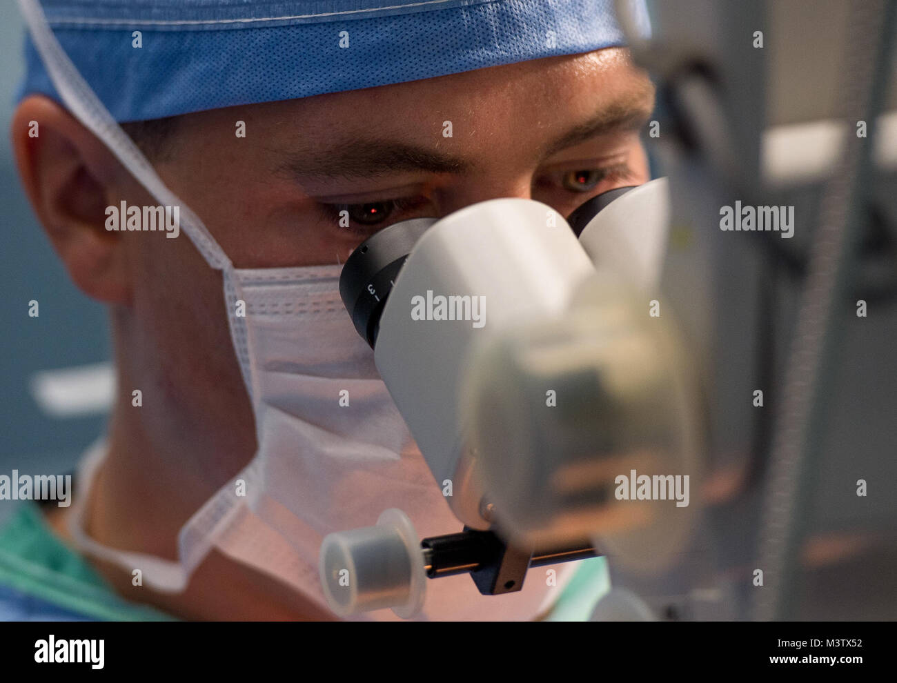 Maj. Brent Mittelstaedt, an ophthalmologist, looks through a microscope during an extracapsular cataract extraction with intraocular implant surgery at the Centro Hospitalario Luis 'Chicho' Fabrega during a medical readiness training exercise in Santiago, Panama, Feb. 6, 2017. The U.S. military medical team was in Panama to help treat individuals with cataracts that otherwise would have gone untreated. Medical readiness training exercises provide U.S. military personnel training in delivery of medical care in austere conditions, promote diplomatic relations between the U.S. and host nations in Stock Photo