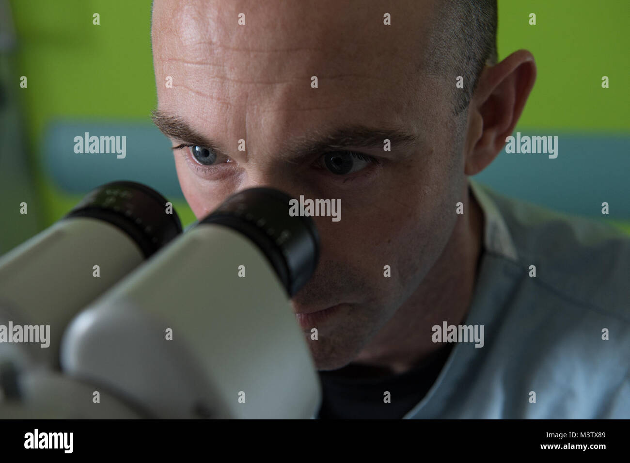 Maj. Brett Davies, an ocular trauma and plastic surgeon, looks through a microscope at the Centro Hospitalario Luis 'Chicho' Fabrega during a medical readiness training exercise in Santiago, Panama, Feb. 7, 2017. The U.S. military medical team was in Panama to help treat individuals with cataracts that otherwise would have gone untreated. Medical readiness training exercises provide U.S. military personnel training in delivery of medical care in austere conditions, promote diplomatic relations between the U.S. and host nations in Central America and provide humanitarian and civic assistance vi Stock Photo