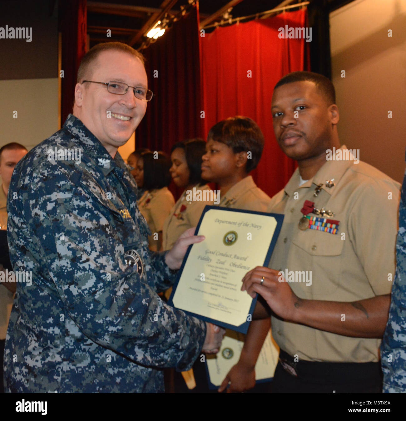 170208-N-SP496-016 SILVERDALE, Wash. (Feb. 8, 2017) – Capt. Alan Schrader (left), Naval Base Kitsap (NBK) commanding officer, presents Culinary Specialist 1st Class Jonathan Yates with the Good Conduct Medal during an all-hands call held at the NBK-Bangor Theater. More than 30 awards and decorations were bestowed to NBK personnel during the event. (U.S. Navy photo by Petty Officer 3rd Class Jane Wood/Released) 170208-N-SP496-016 by Naval Base Kitsap (NBK) Stock Photo