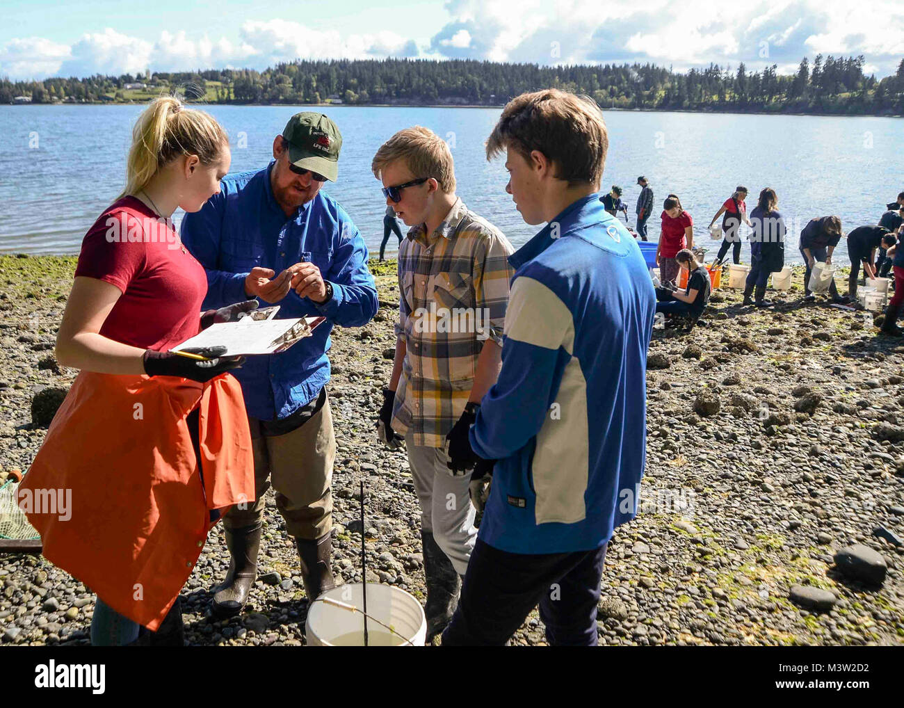 170428-N-VH385-112 INDIAN ISLAND, Wash., (April 28, 2017) – Lyle Britt, a reasearcher with the Alaska Fishery and Science Center, shows a crab to some students from Blue Heron Middle School during a community outreach beach seining with the United States Geological Survey (USGS) at Naval Magazine Indian Island. This is the third year the USGS has teamed up with Blue Heron Middle School and Naval Magazine Indian Island to conduct beach seinings in preparation for the Kilsut Spit waterflow to be opened between Marrowstone and Indian Island. (U.S. Navy photo by Mass Communication Specialist 3rd C Stock Photo