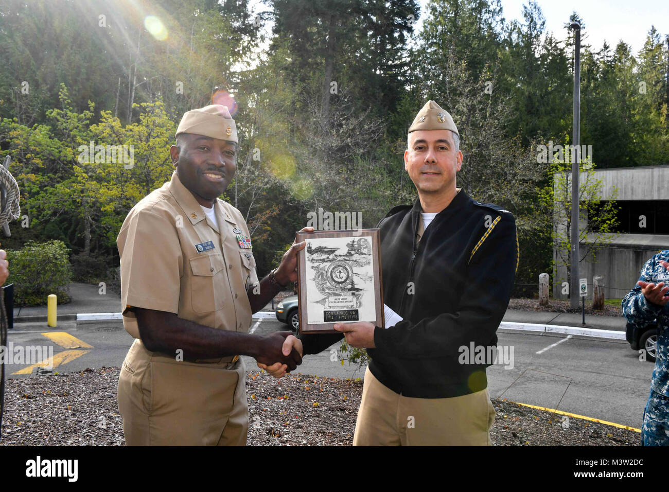 170428-N-EC099-015 SILVERDALE, Wash. (April 28, 2017) Capt. Tom Zwolfer, chief of staff, Navy Region Northwest, (right) presents Senior Chief Navy Counselor Jean-Hero Lamy with the Retention Excellence Award in front of Navy Region Northwest. The Retention Excellence Award is bestowed to commands that meet a minimum score of 90 points on the Annual Command Information Program Review, aggregate Zone ÒAÓ attrition rate less than five percent, and uphold no ÒFailed To SubmitÓ incidences in the Career Navigator System. (U.S. Navy photo by Mass Communication Specialist 3rd Class Charles D. Gaddis I Stock Photo