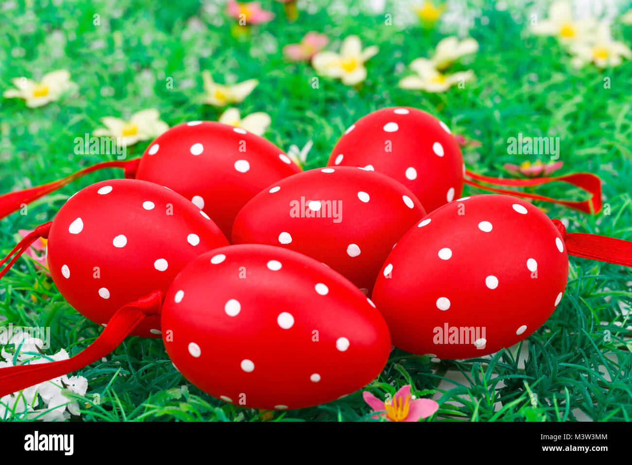 Easter red spotted eggs on artificial grass background. Stock Photo