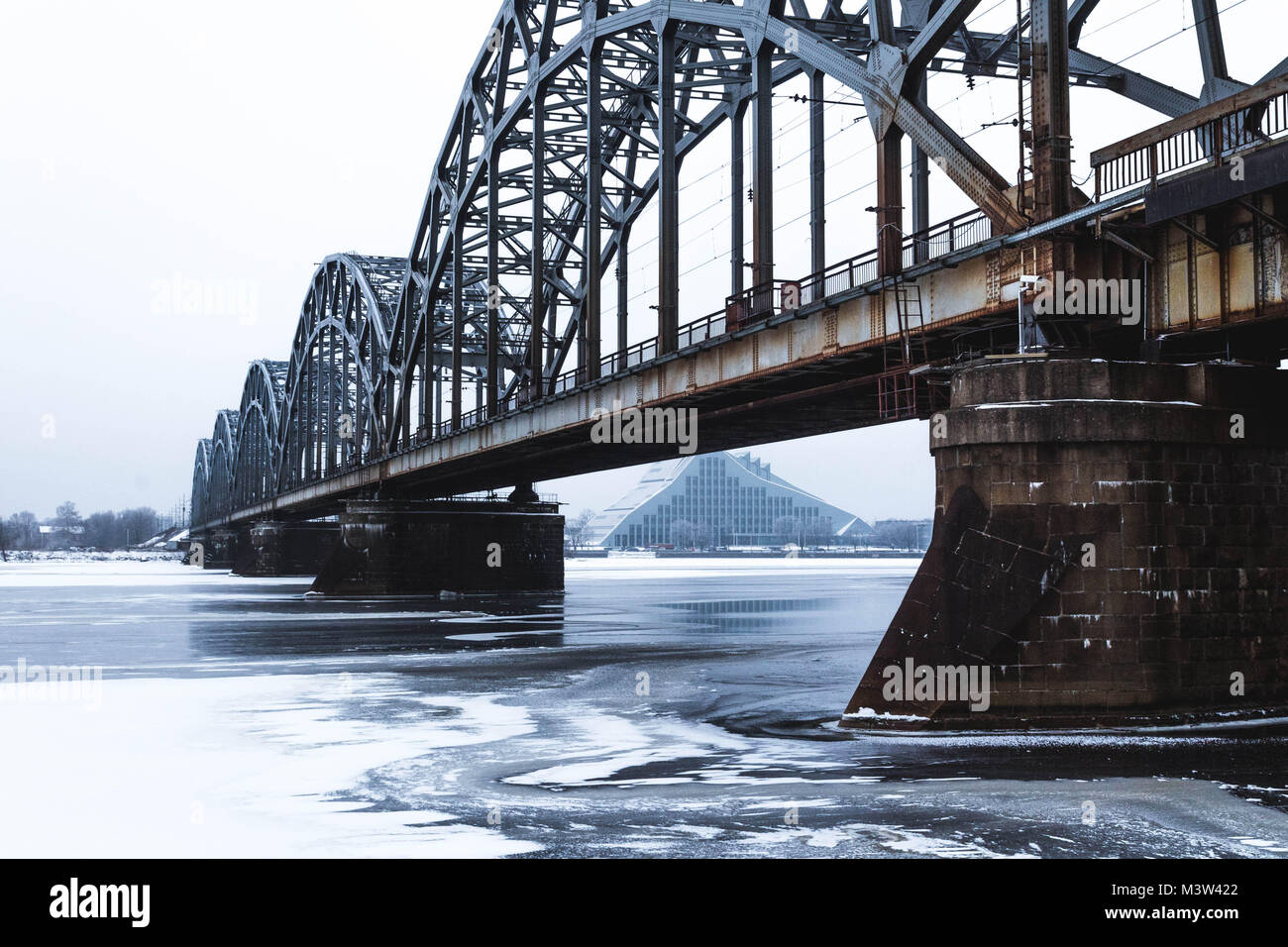The Railway Bridge in a winter day with the National Library of Latvia on the Background Stock Photo