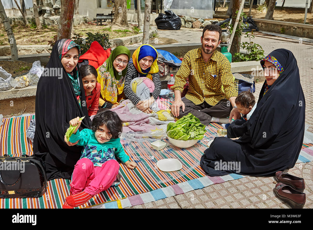 Tehran, Iran - April 28, 2017: big Iranian family is spending a day off making a picnic in the park, they are smiling and laughing. Stock Photo