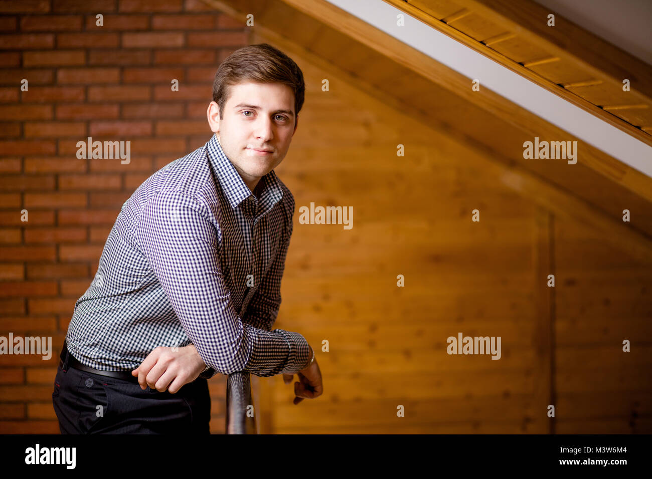 Smiling Young Man Leaning Against Brick Wall Stock Photo - Alamy