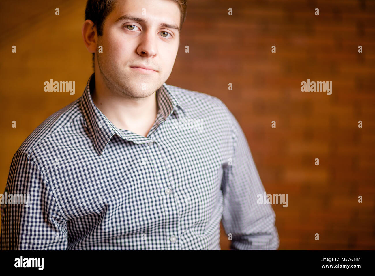 Smiling Young Man Leaning Against Brick Wall Stock Photo - Alamy