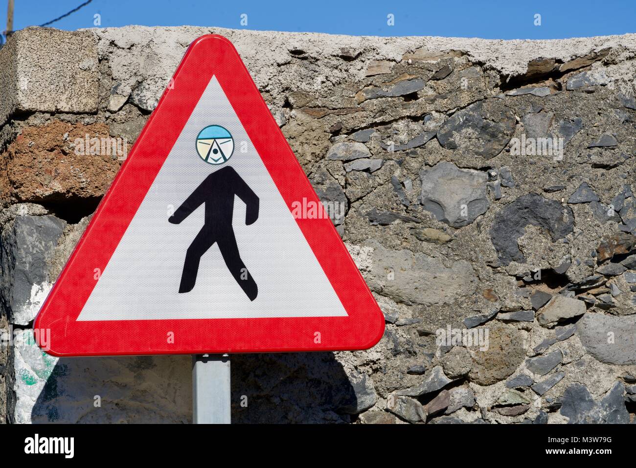 close-up of a funny attention pedestrian road sign with an individual face Stock Photo