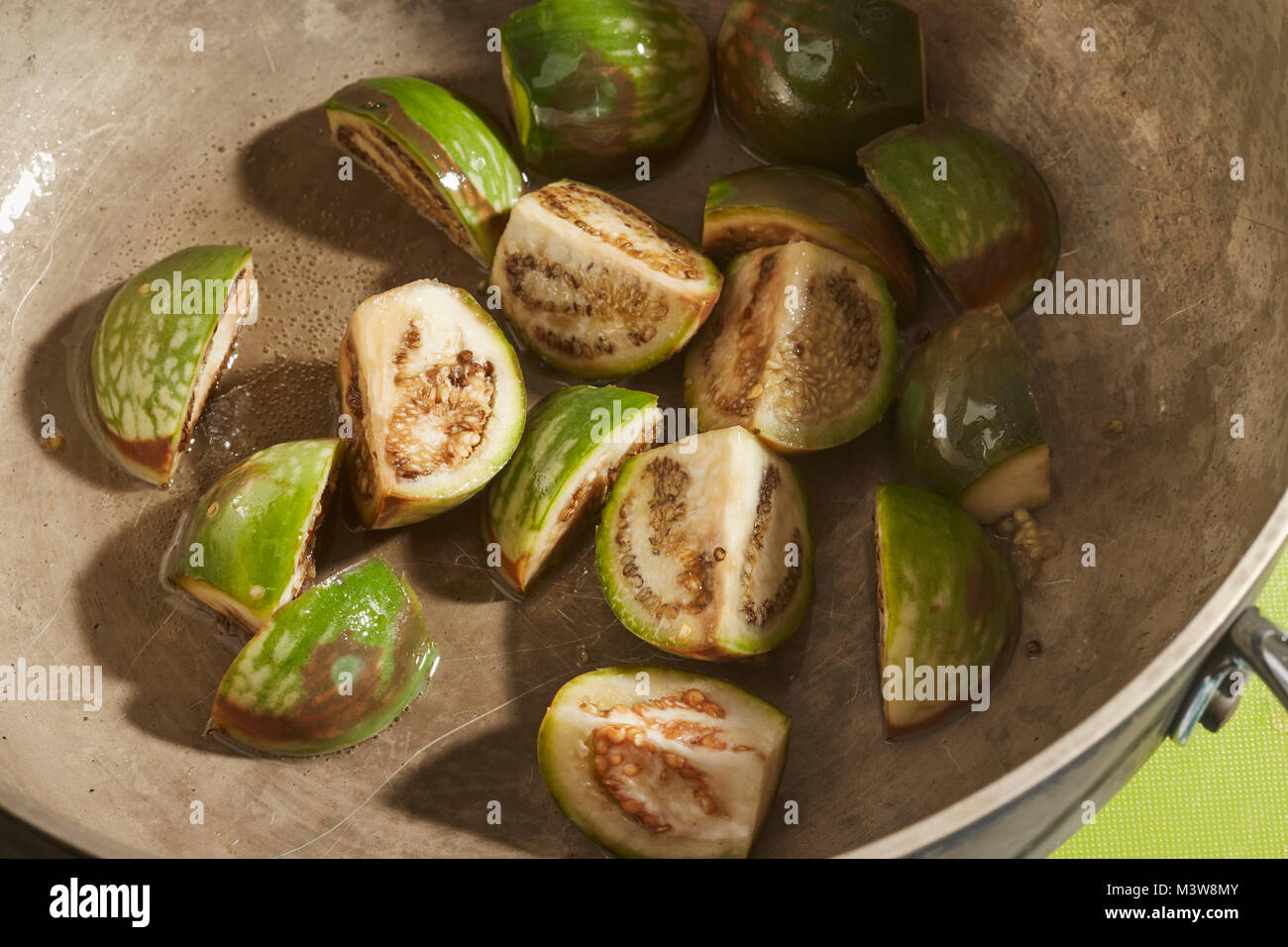 Pieces of Thai Eggplant frying in a pan Stock Photo