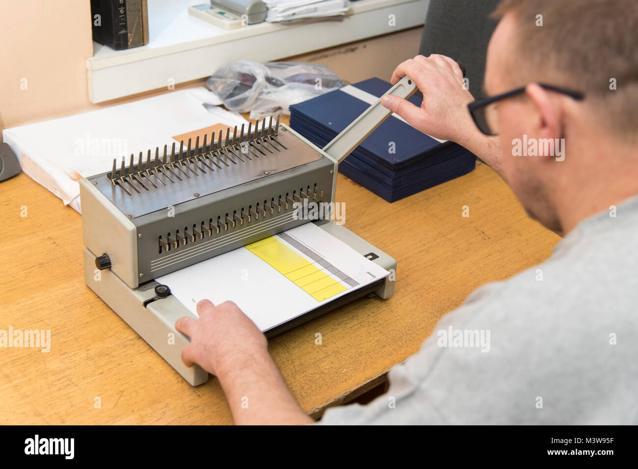 Using a paper binding machine Stock Photo Alamy