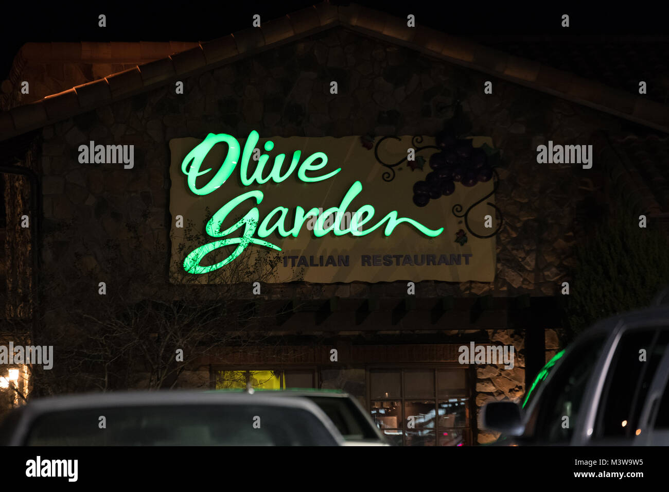 WILSON, NC - JANUARY 25, 2018: An Olive Garden restaurant sign is illuminated at night. Olive Garden is an American casual dining restaurant chain spe Stock Photo