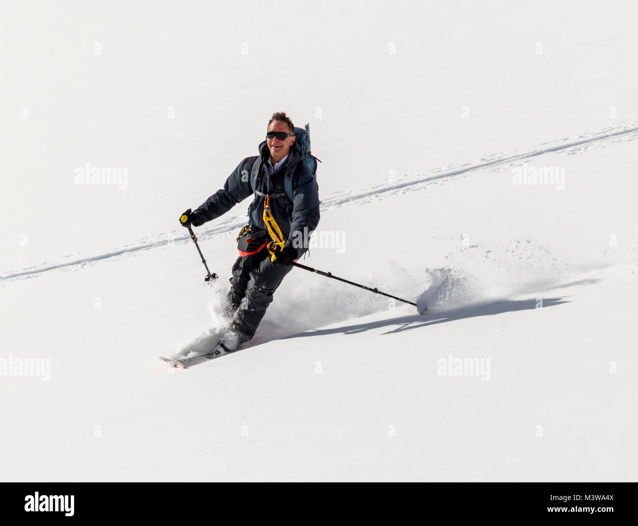 Alpine ski mountaineer skiing downhill in Antarctica; Rongé Island