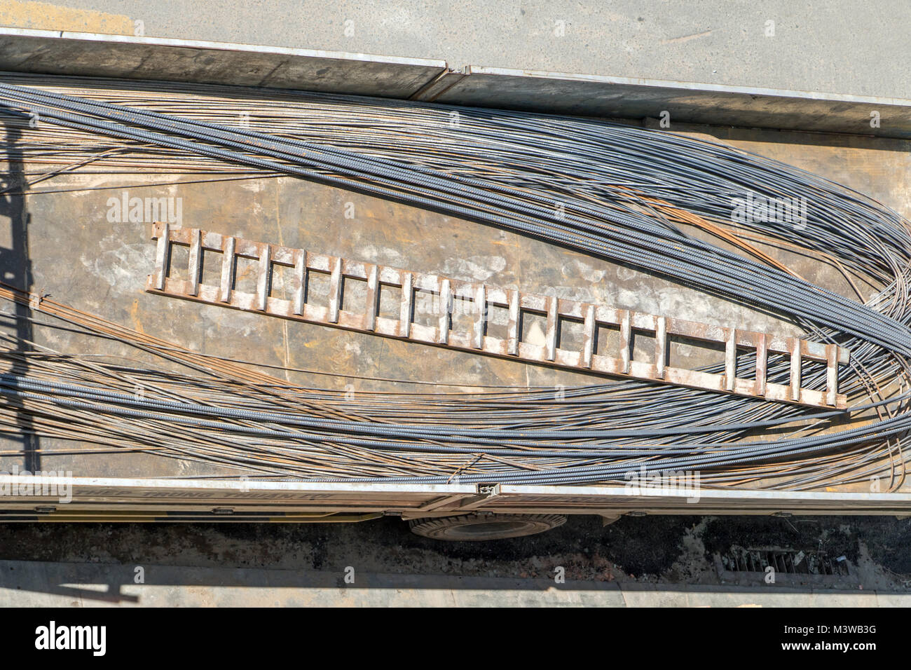 Transportation of building material. Steel rods with an iron ladder loaded on a lorry. Stock Photo