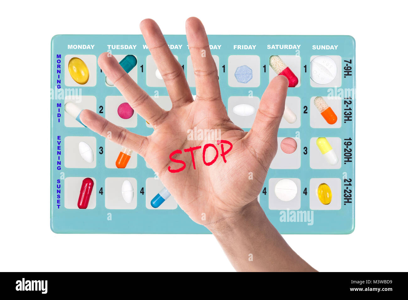 Blue pill box for storage of drugs, with inscriptions in french, of moment of the day of the week on white with a hand with a stop written in red in the middle: symbol of danger Stock Photo