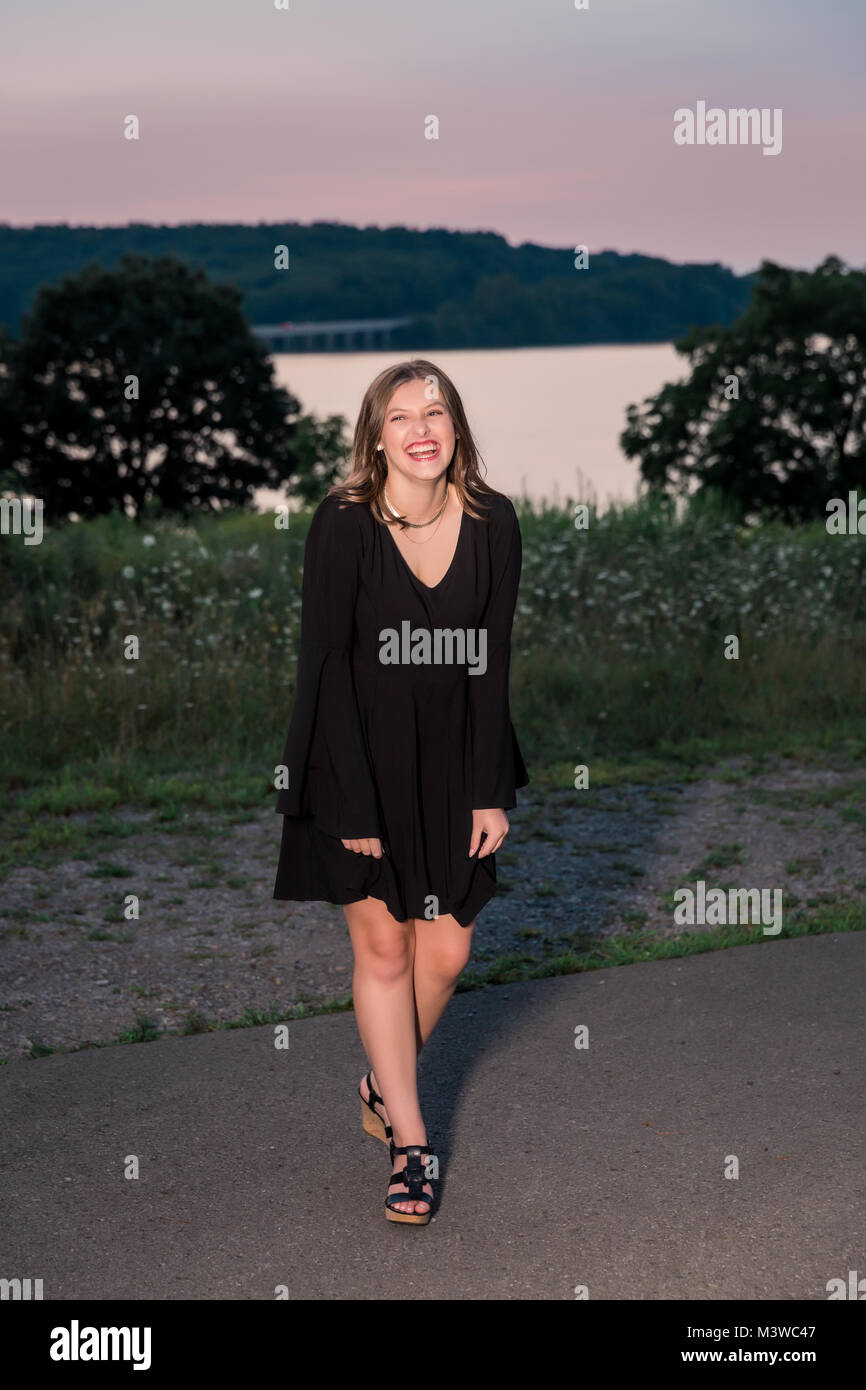 High school senior girl portraits outside during summertime. One person. Beautiful brunette teenage female. Stock Photo