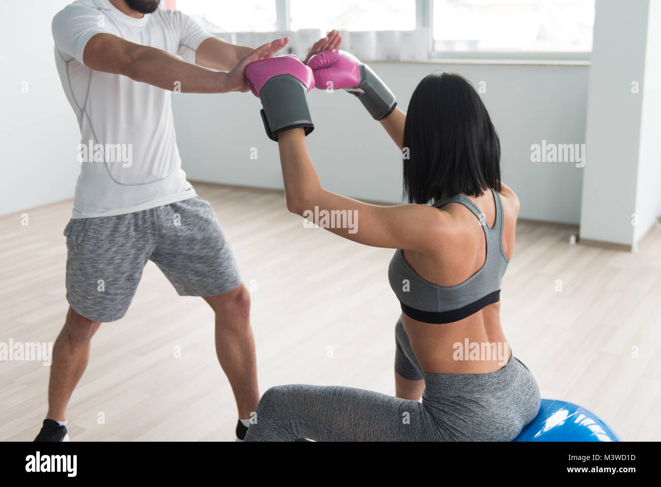 Woman Boxer MMA Fighter Practice Her Skills With Personal Trainer In Gym Stock Photo