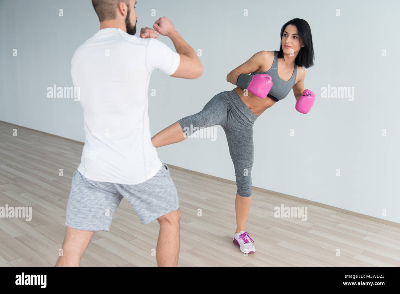 Woman Boxer MMA Fighter Practice Her Skills With Personal Trainer In Gym Stock Photo