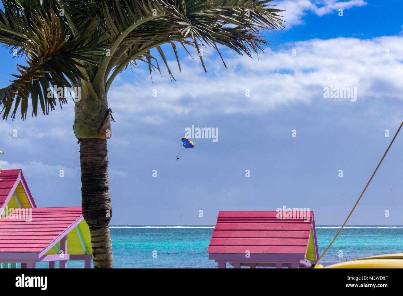 A parasail floats past the colorful roofs of San Pedro next to the blue