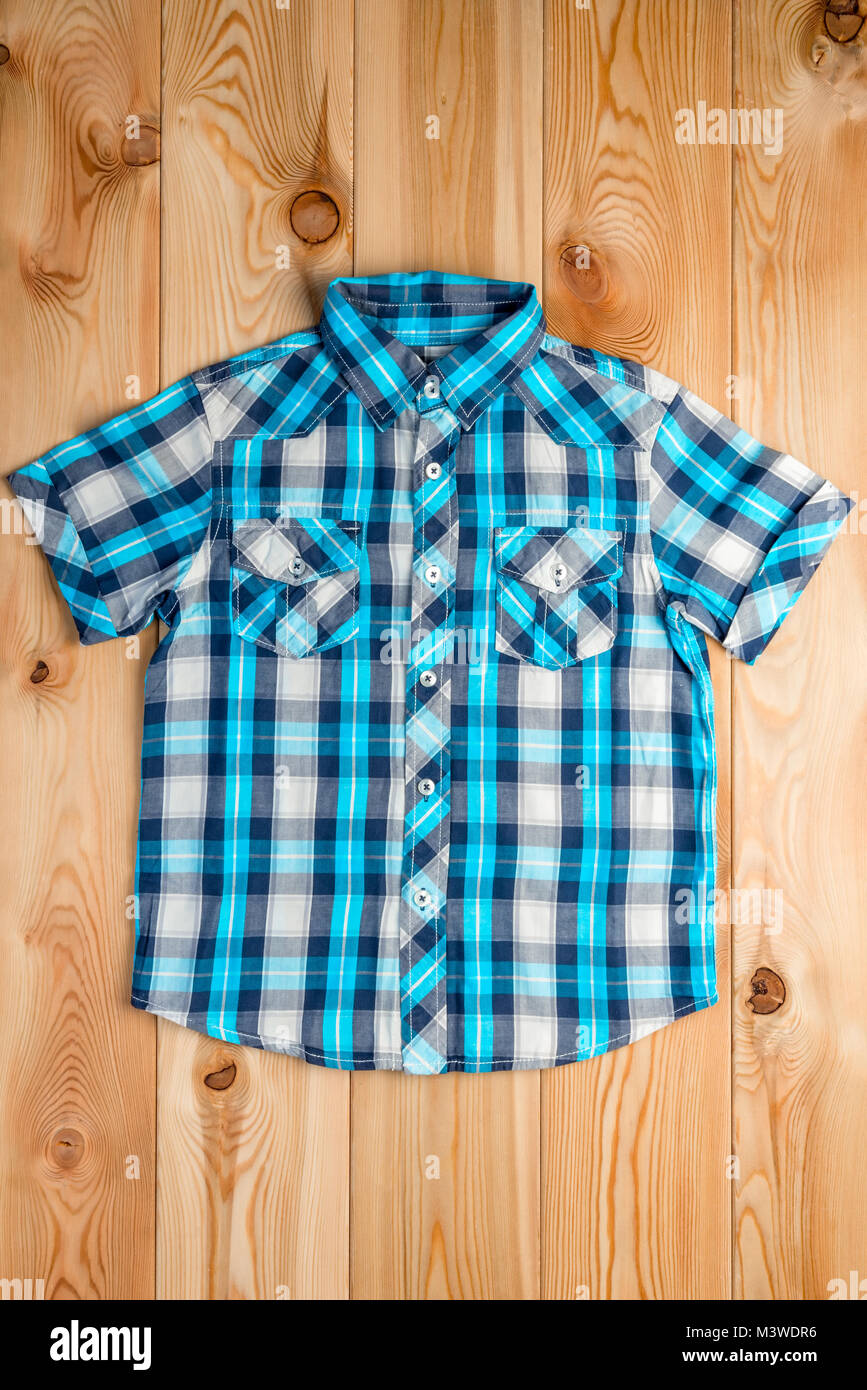 blue checkered shirt for a boy in a rural style on the wooden floor Stock Photo